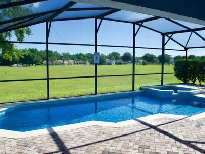 a swimming pool with a tent and a field at Holiday Home Entspannende Familienvilla mit privatem Pool und Spa- Große Lanai mit reichlich by Interhome in Orlando