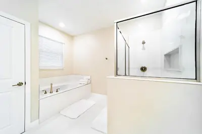 a white bathroom with a tub and a shower at Storey Lake Resort 9Q c/ Piscina & Game Room in Kissimmee