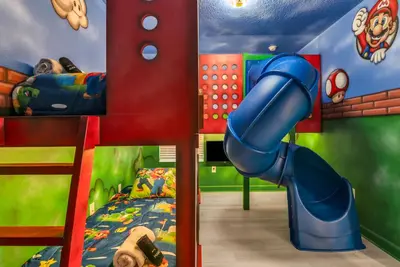 a childs room with a blue slide at Disney & Universal House with Pool & Arcade in Kissimmee