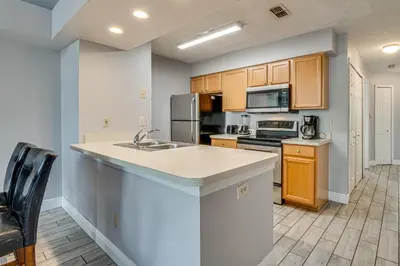 a kitchen with a sink and a stove top oven at Family Theme Park Hub with Pool in Kissimmee in Kissimmee