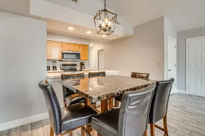 a kitchen and dining room with a table and chairs at Family Theme Park Hub with Pool in Kissimmee in Kissimmee