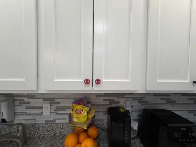 a kitchen with white cabinets and a bunch of oranges at Disney Princess and Heroes Apartment Accessible in Orlando