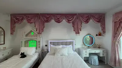 a bedroom with two beds and a cat sitting on the bed at Disney Princess and Heroes Apartment Accessible in Orlando
