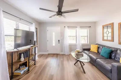 a living room with a couch and a flat screen tv at The Pineapple Express in Orlando