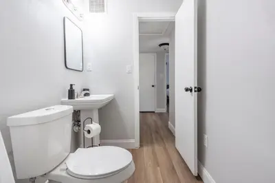 a white bathroom with a toilet and a sink at The Pineapple Express in Orlando