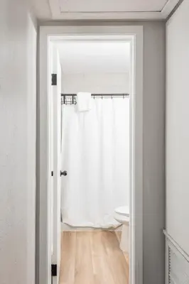 a bathroom with a white shower curtain and a toilet at The Pineapple Express in Orlando