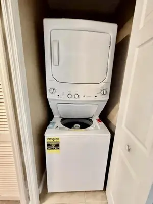 a washer and dryer with a tv on top of it at Entire Condo 3Bed 2Bath 5 mins to Disney Park in Orlando