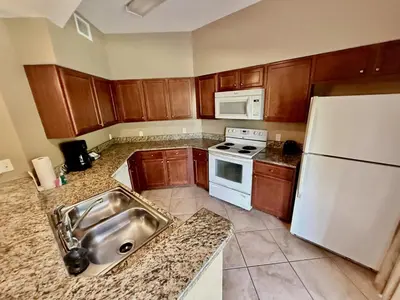 a kitchen with a sink and a white refrigerator at Entire Condo 3Bed 2Bath 5 mins to Disney Park in Orlando