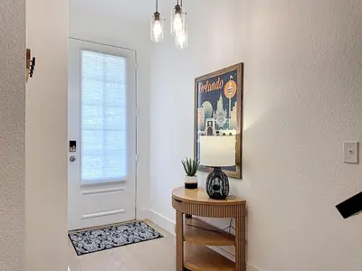 a room with a table with a lamp and a door at The Roundup Retreat! in Orlando