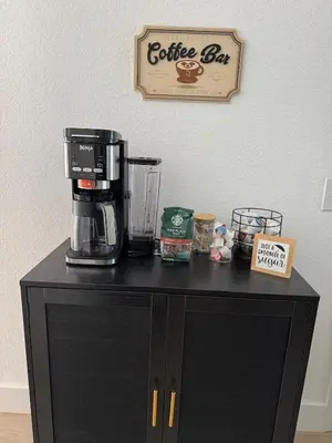 a coffee bar with a coffee maker on top of it at The Roundup Retreat! in Orlando