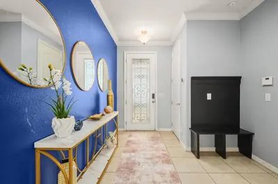 a hallway with blue walls and a table and a mirror at Comfort & Charm in Central Florida in Sanford