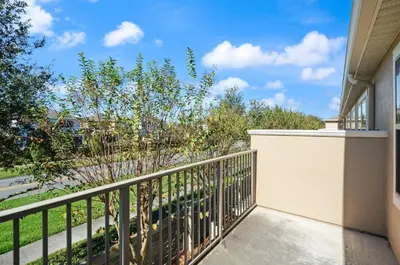 a balcony of a house with a fence and trees at Comfort & Charm in Central Florida in Sanford