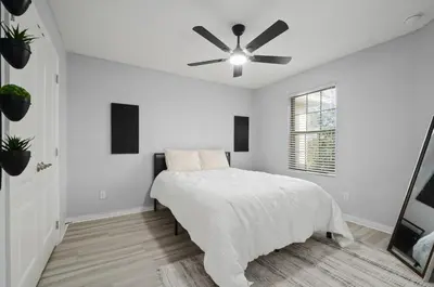 a white bedroom with a bed and a ceiling fan at Comfort & Charm in Central Florida in Sanford