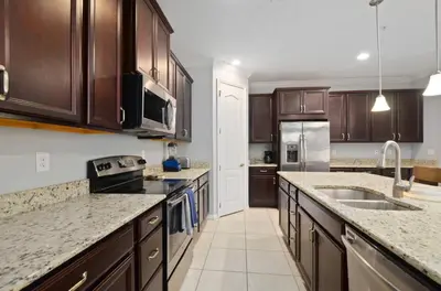 a kitchen with wooden cabinets and granite counter tops at Comfort & Charm in Central Florida in Sanford