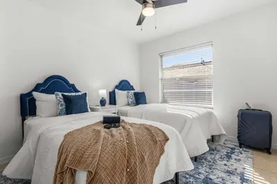 a bedroom with two beds and a window at Residentas Hali Ridge in Orlando