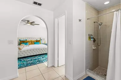 a white bathroom with a bed and a shower at Residentas Hali Ridge in Orlando