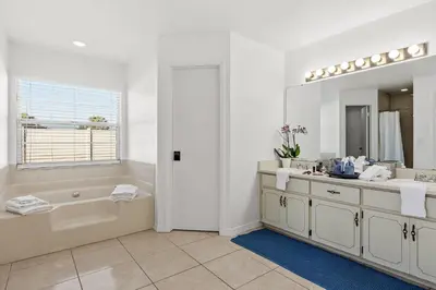 a bathroom with a tub and a sink and a mirror at Residentas Hali Ridge in Orlando
