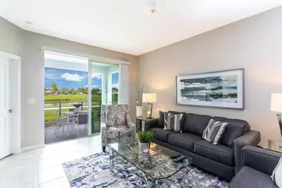 a living room with a couch and a glass table at Lake view Near Disney Resort w Lazy River 108 in Kissimmee