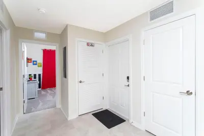 a hallway with white doors and a red room at Lake view Near Disney Resort w Lazy River 108 in Kissimmee