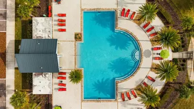 an overhead view of a swimming pool with beach chairs and palm trees at Mario & Fairy 3BR Condo w Free Water Park 303 in Kissimmee