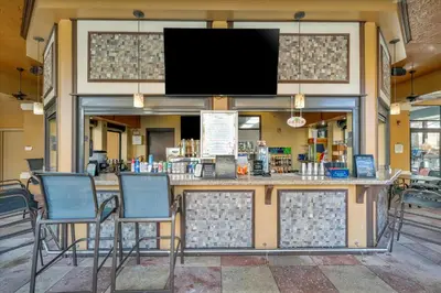 a bar with two chairs and a flat screen tv at Free Breakfast & Parking 2B Disney Resort Condo in Orlando