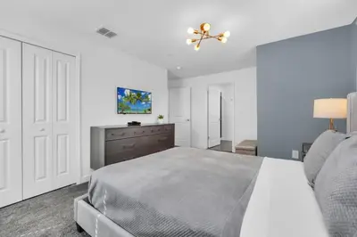 a white bedroom with a bed and a ceiling fan at Luxury, Luxury, Luxury Pool Home! townhouse in Kissimmee