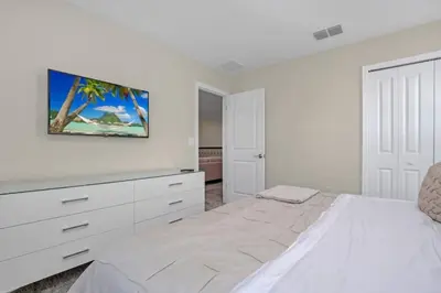 a white bedroom with a bed and a dresser at 9 Bedroom With Everything For Happiness! home in Kissimmee