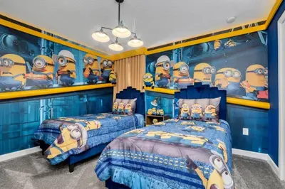 a bedroom with two beds and a blue wall with minions at 9 Bedroom With Everything For Happiness! home in Kissimmee