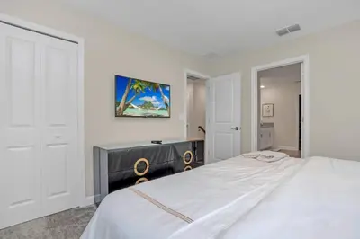 a white bedroom with a large bed and a desk at 9 Bedroom With Everything For Happiness! home in Kissimmee