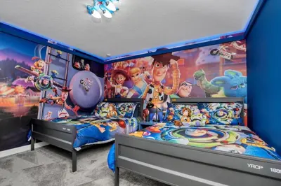 a bedroom with two beds and a disney movie mural at 9 Bedroom With Everything For Happiness! home in Kissimmee