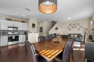 a kitchen and dining room with a wooden table and chairs at Relaxing Resort Townhome Close to Disney in Kissimmee