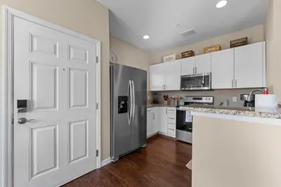a kitchen with white cabinets and a refrigerator at Relaxing Resort Townhome Close to Disney in Kissimmee