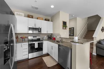 a kitchen with white cabinets and stainless steel appliances at Relaxing Resort Townhome Close to Disney in Kissimmee