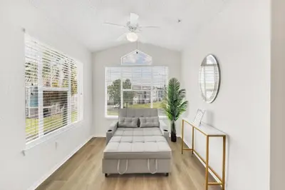 a living room with a couch and a ceiling fan at Grand Luxury 2BR Penthouse near Disney Parks in Kissimmee