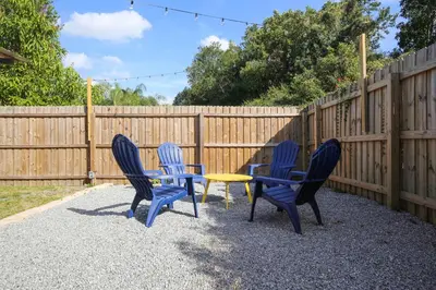 four blue chairs and a table in front of a fence at Bungalow near Universal, Disney, and Downtown Orlando in Orlando