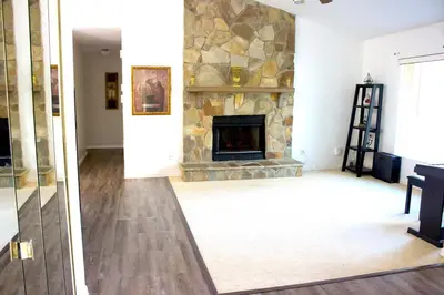 a living room with a stone fireplace at 4 Bedroom Private Pool House - 5 Mi to Convention Center & 7 Mi to Disney in Orlando