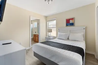 a white bedroom with a bed and a white desk at Casa 6Q Bella Vida Resort – Perto Disney in Kissimmee