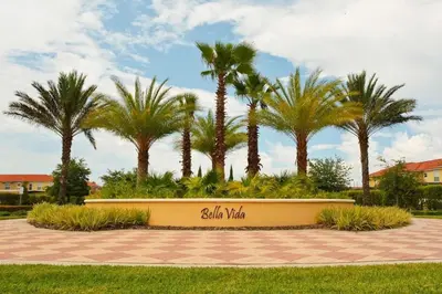 a sign in a park with palm trees at Casa 6Q Bella Vida Resort – Perto Disney in Kissimmee