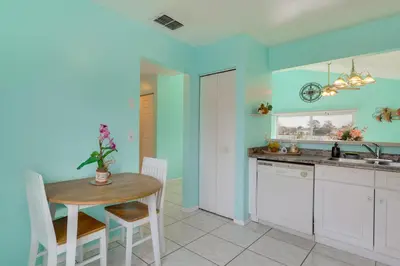 a kitchen with a table and a dining room at Bright Lakefront Sanford Home with Community Pool in Sanford