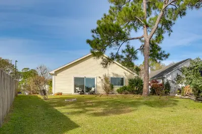 a house with a tree in a yard at Bright Lakefront Sanford Home with Community Pool in Sanford