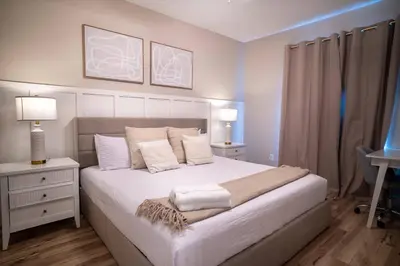 a bedroom with a bed with white sheets and pillows at Family 3BR Home in Lucaya Resort in Kissimmee