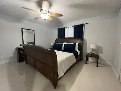 a bedroom with a bed and a ceiling fan at Beautiful pool home 15 minutes from Disney! in Kissimmee