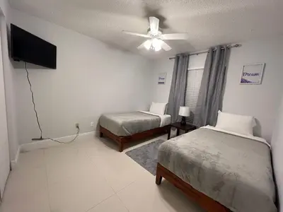a bedroom with two beds and a ceiling fan at Beautiful pool home 15 minutes from Disney! in Kissimmee