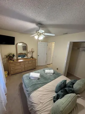 a bedroom with a large bed and a ceiling fan at 4813 Pliny Court in Kissimmee