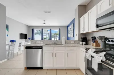 a kitchen with white cabinets and a counter top at Disney Min Away - Pool Patio & BBQ in Orlando