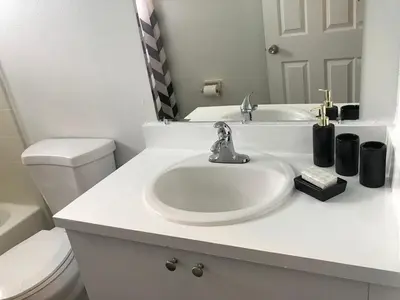 a white bathroom with a sink and a toilet at 10 minutes to all Disney park for vacation in Kissimmee