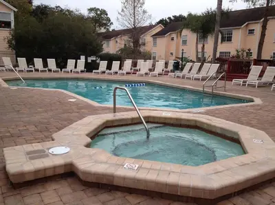 a swimming pool with chairs and a hot tub at 10 minutes to all Disney park for vacation in Kissimmee