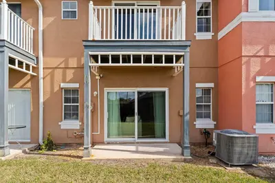 a building with a door and a balcony at Peaceful Palms Stay for 6 in Kissimmee