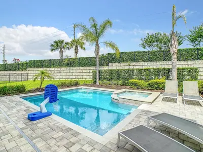 a swimming pool with two chairs and a fence at 160 Minton Loop in Orlando