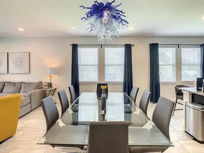 a dining room and living room with a table and chairs at 160 Minton Loop in Orlando